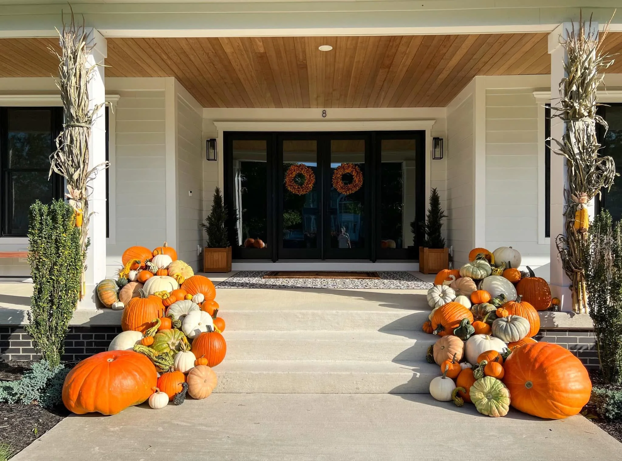 The Grand Harvest fall porch pumpkin display by Detroit Pumpkin Company